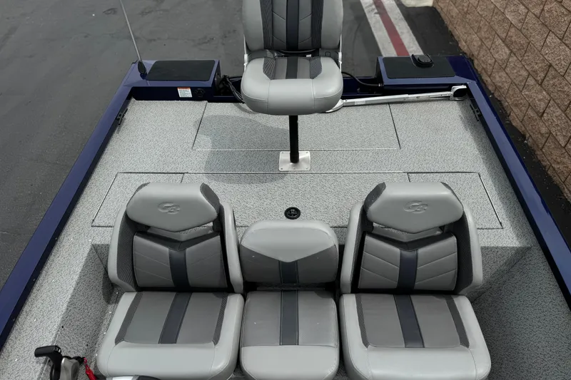 Slide: The Image of 2024 G3 Sportsman 1710 boat interior with gray seating and carpeted deck. - 15