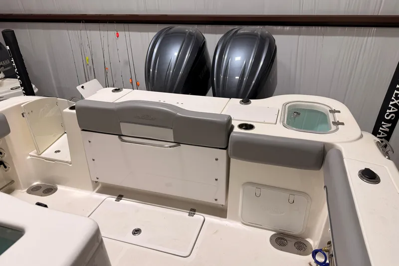 Slide: The Image of 2021 NauticStar 28 XS boat interior with dual Yamaha engines and fishing rod holders. - 13