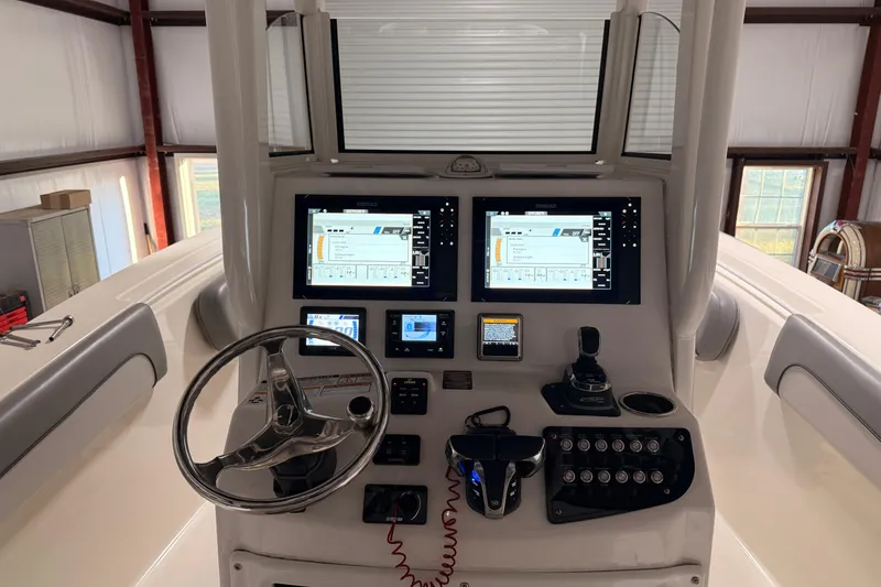Slide: The Image of 2021 NauticStar 28 XS boat dashboard with dual Simrad displays and steering wheel. - 14