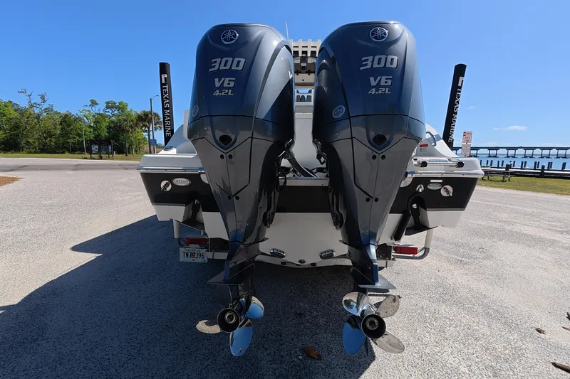 Slide: The Image of 2021 NauticStar 28 XS boat with twin Yamaha 300 V6 outboard engines, parked near a waterfront. - 3