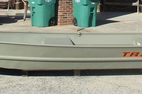 The Image of 2026 Tracker Grizzly 14 Jon boat on pavement near green bins. - 1