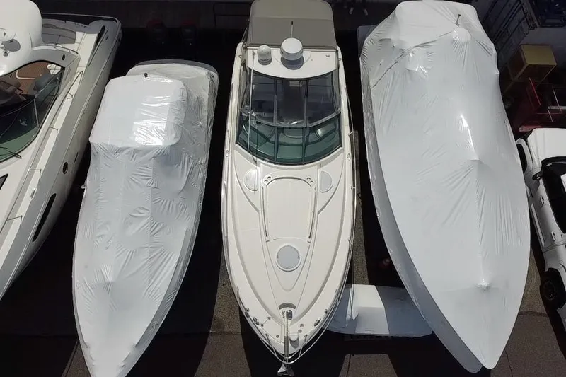 Slide: The Image of 2009 Monterey 320 Sport Yacht in storage, surrounded by other boats, under clear blue sky. - 10