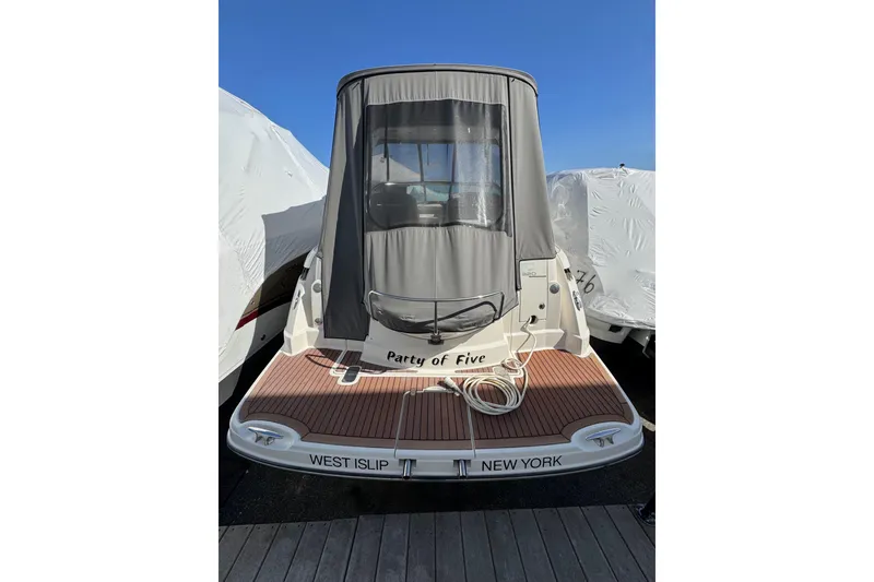 Slide: The Image of 2009 Monterey 320 Sport Yacht docked, rear view with cover, named "Party of Five". - 13