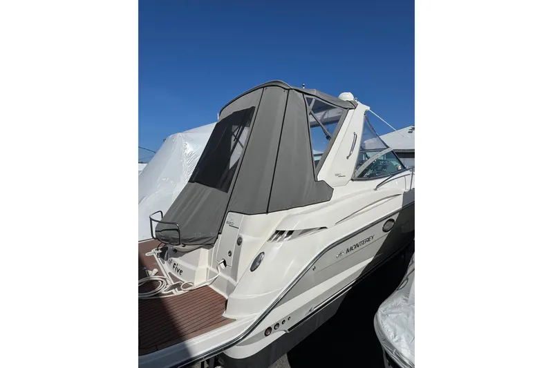 Slide: The Image of 2009 Monterey 320 Sport Yacht, rear view with seating and cover, docked outdoors. - 14