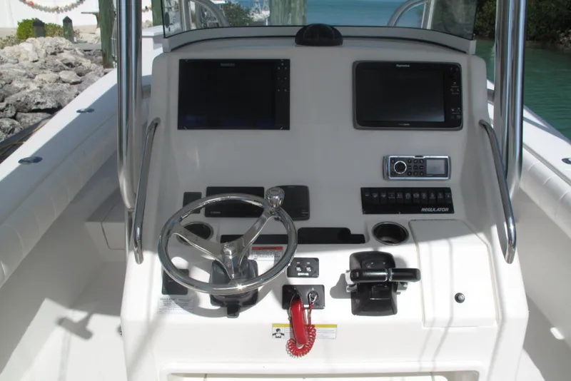 Slide: The Image of 2013 Regulator 32 Forward Seating boat dashboard with steering wheel and navigation controls. - 13