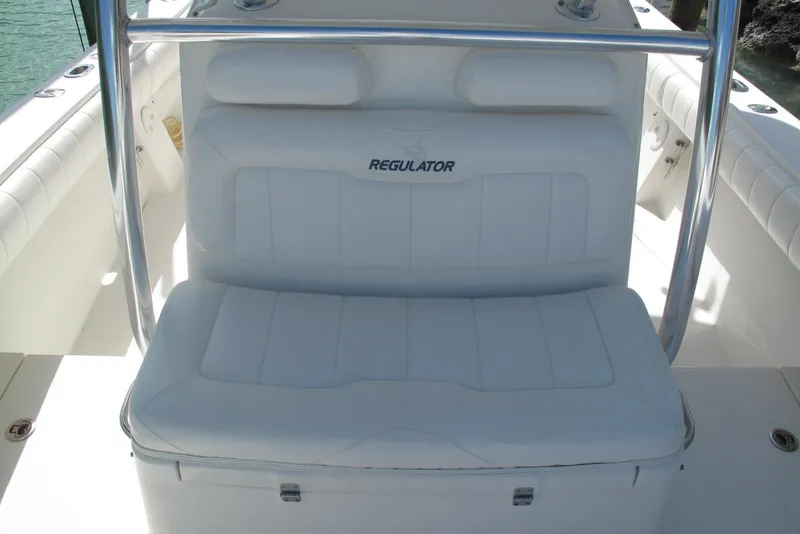 Slide: The Image of 2013 Regulator 32 Forward Seating boat with white cushioned seats and stainless steel rail. - 2