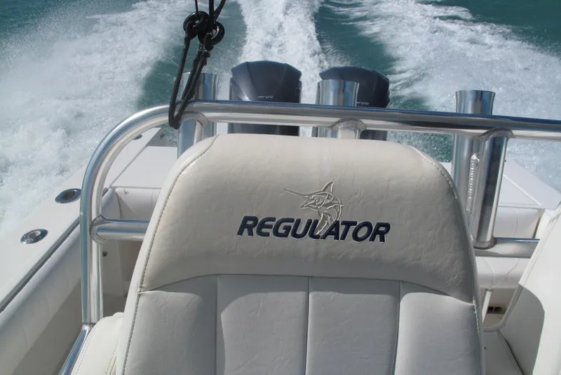 Slide: The Image of 2013 Regulator 32 Forward Seating boat cruising on water, showcasing logo on seat. - 24