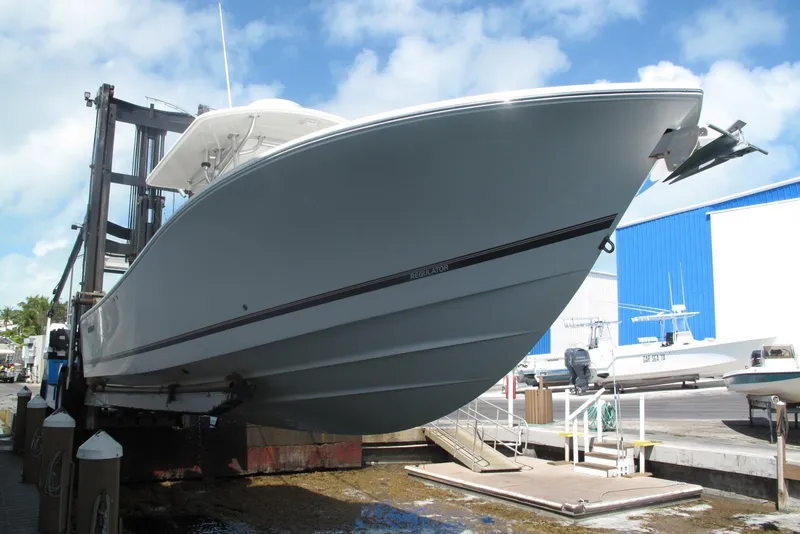 Slide: The Image of 2013 Regulator 32 Forward Seating boat on lift at marina. - 32