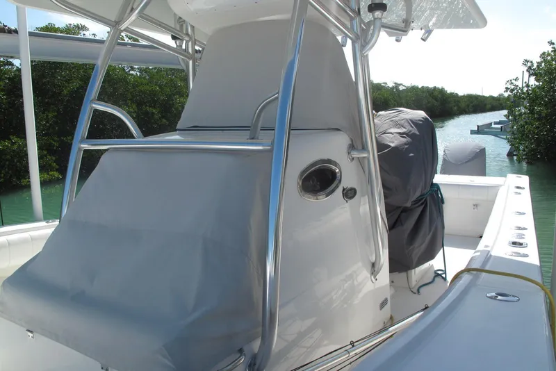 Slide: The Image of 2013 Regulator 32 Forward Seating boat with covered console, docked near lush greenery. - 8