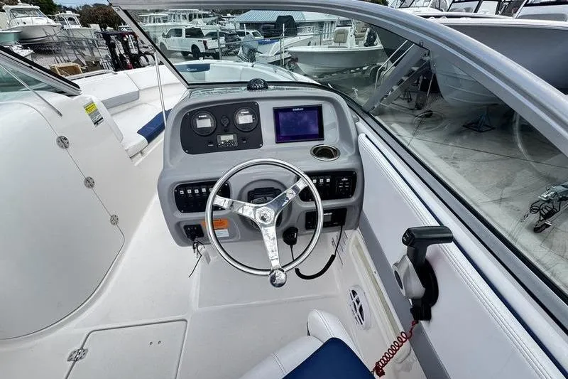 Slide: The Image of 2021 Robalo R227 Dual Console boat dashboard with steering wheel and navigation controls. - 18