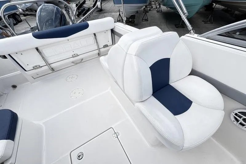 Slide: The Image of 2021 Robalo R227 Dual Console boat interior with white and blue seating. - 21
