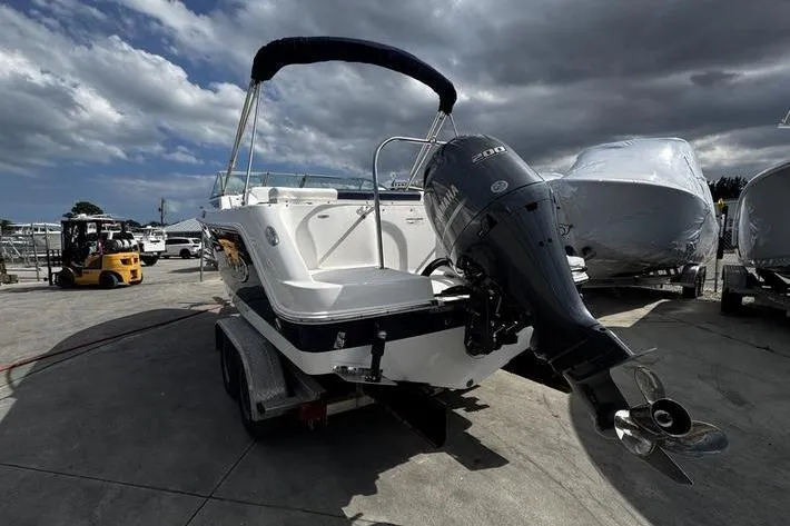 Slide: The Image of 2021 Robalo R227 Dual Console boat with Yamaha 200 engine on trailer, under cloudy sky. - 4