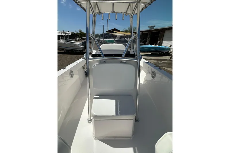Slide: The Image of 2023 LFG 22CC boat interior with seating and T-top under clear sky. - 16