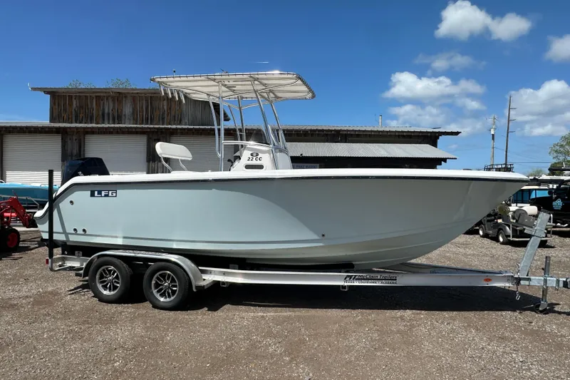 Slide: The Image of 2023 LFG 22CC boat on trailer, parked outdoors under a clear blue sky. - 2