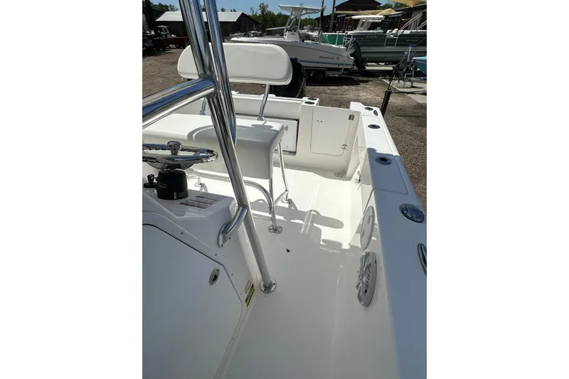 Slide: The Image of 2023 LFG 22CC boat interior with steering wheel and seating, docked outdoors. - 20