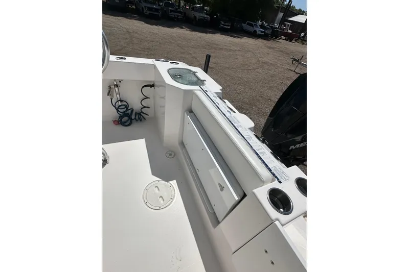 Slide: The Image of 2023 LFG 22CC boat interior with storage, cup holders, and coiled hose. - 22