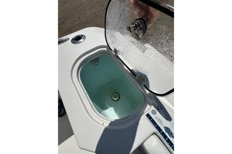 Slide: The Image of Open compartment on 2023 LFG 22CC boat with transparent lid and water droplets. - 25