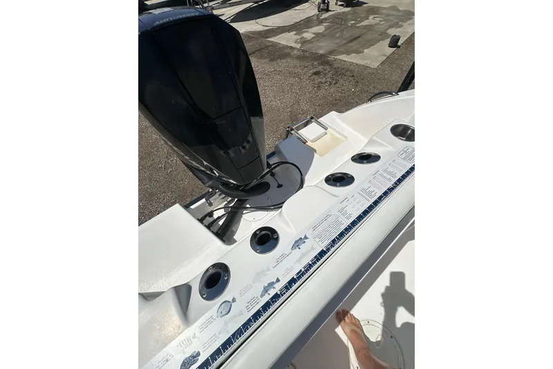 Slide: The Image of 2023 LFG 22CC boat deck with motor, cup holders, and fish ruler. - 26