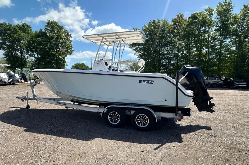 Slide: The Image of 2023 LFG 22CC boat on trailer, parked outdoors under a clear blue sky. - 6