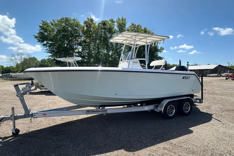 Slide: The Image of 2023 LFG 22CC boat on trailer, parked outdoors under clear blue sky. - 7