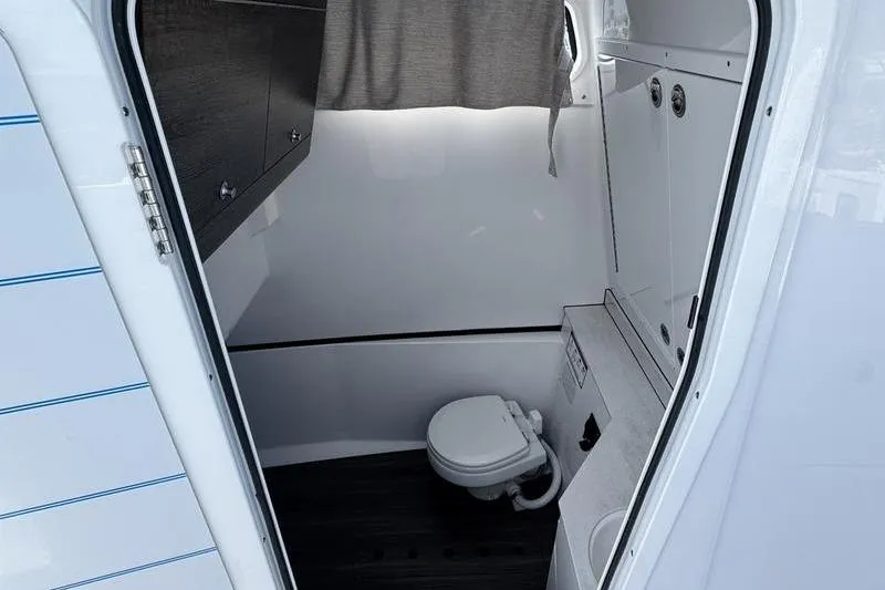 Slide: The Image of 2026 Sportsman Heritage 321 Center Console boat interior with compact bathroom. - 11