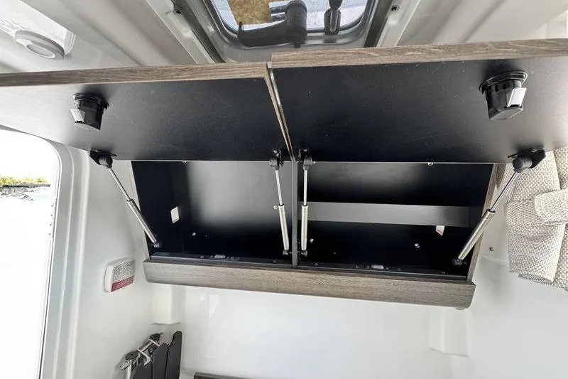 Slide: The Image of 2026 Sportsman Heritage 321 Center Console interior storage compartment with open cabinet doors. - 14