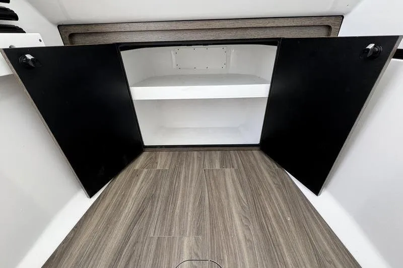 Slide: The Image of 2026 Sportsman Heritage 321 Center Console interior storage with open black cabinet doors. - 15