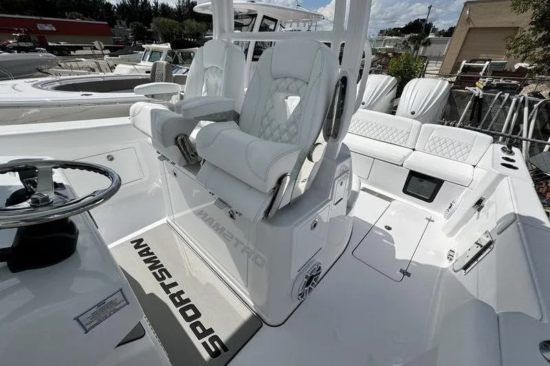 Slide: The Image of 2026 Sportsman Heritage 321 Center Console boat interior with white seating and steering wheel. - 19