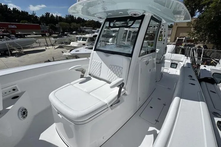 Slide: The Image of 2026 Sportsman Heritage 321 Center Console boat with sleek white seating and modern design. - 8