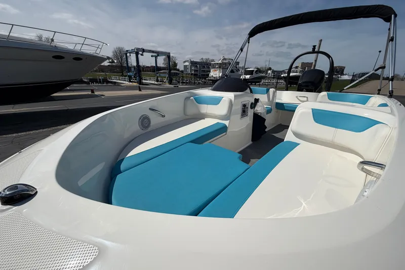 Slide: The Image of 2021 Bayliner Element E16 boat with blue and white seating, docked at a marina. - 17