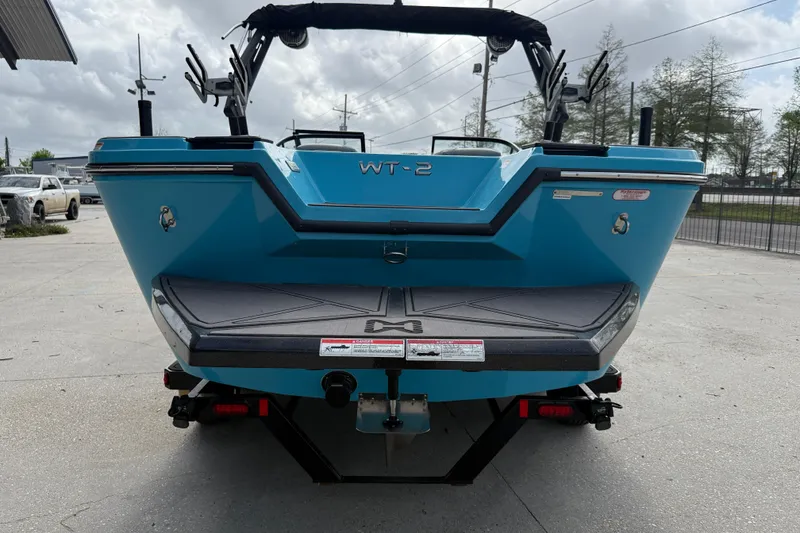 Slide: The Image of 2023 Heyday WT-2DC boat rear view, showcasing sleek blue design and swim platform. - 5