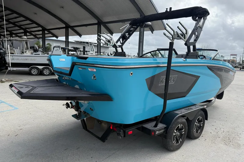 Slide: The Image of 2023 Heyday WT-2DC boat in vibrant blue on a trailer at a marina. - 6
