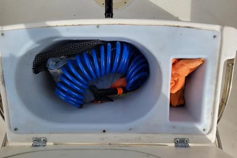 Slide: The Image of Storage compartment of 2010 Trophy 1703 Center Console with coiled hose and towels. - 22