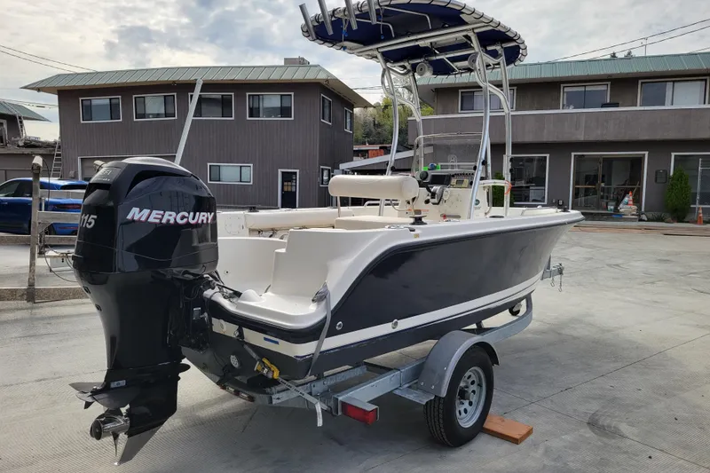 Slide: The Image of 2010 Trophy 1703 Center Console boat with Mercury engine on trailer, parked outdoors. - 4