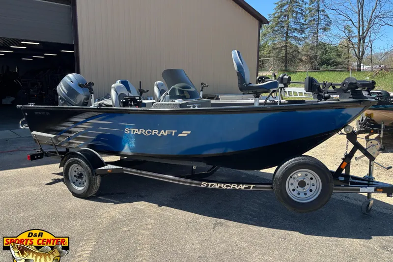 The Image of 2019 Starcraft Stealth 166 SC boat on trailer, parked outdoors near a building. - 17
