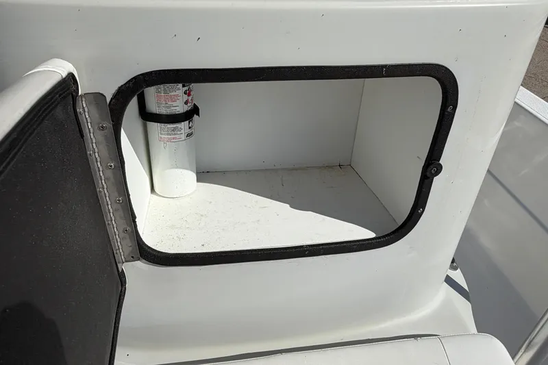 Slide: The Image of Open storage compartment on 2017 Epic 23 Sport Console boat with fire extinguisher inside. - 14