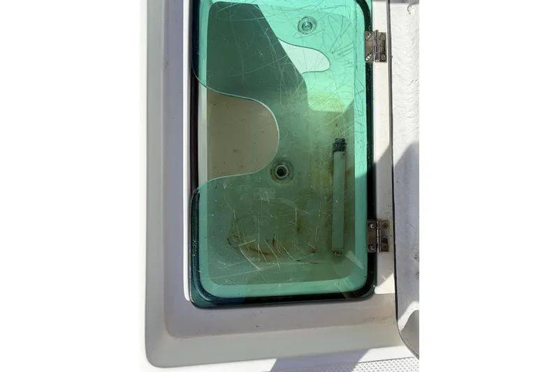 Slide: The Image of Glass compartment on a 2017 Epic 23 Sport Console boat, showing scratches and hinges. - 24