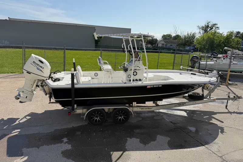 Slide: The Image of 2017 Epic 23 Sport Console boat on trailer with Suzuki outboard motor, parked outdoors. - 6