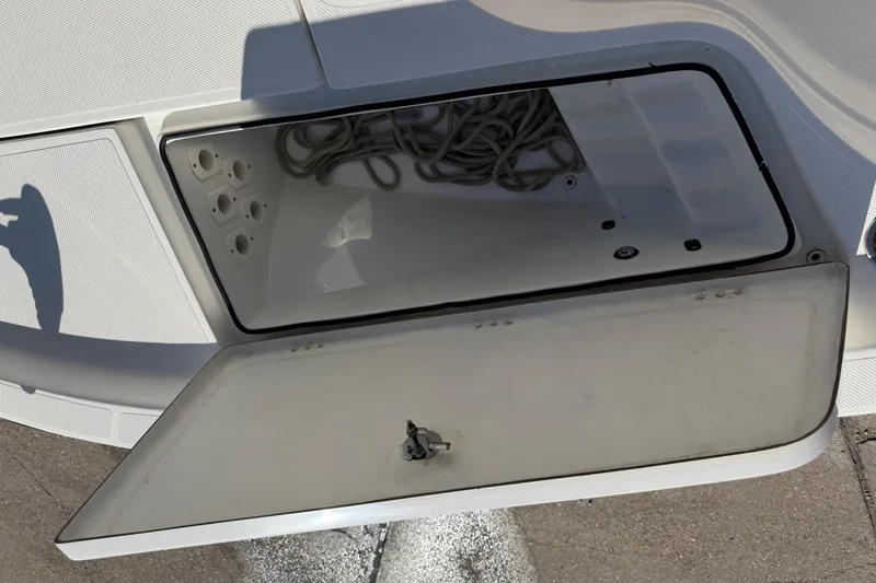 Slide: The Image of Open storage compartment on 2017 Epic 23 Sport Console boat with coiled rope inside. - 9