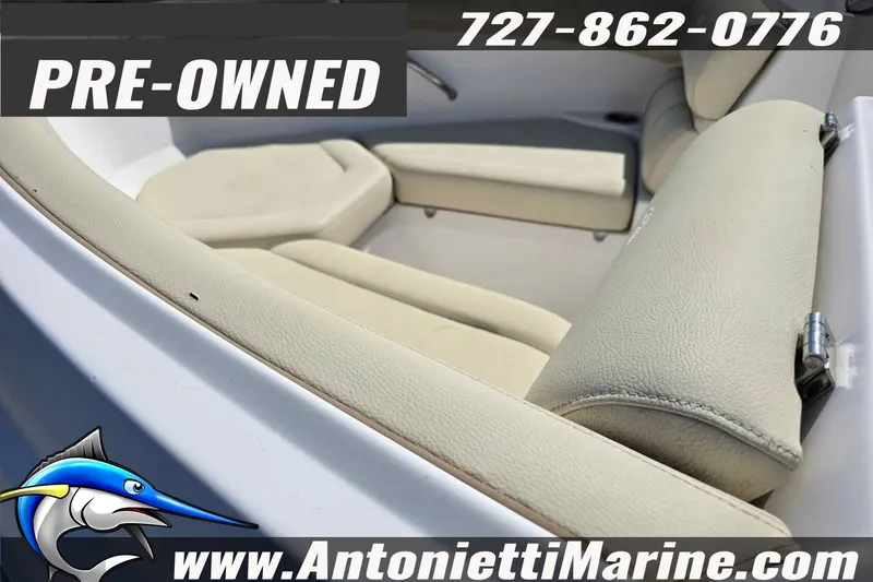Slide: The Image of Pre-owned 2020 Regal 21 OBX boat interior with beige seating, contact details visible. - 13