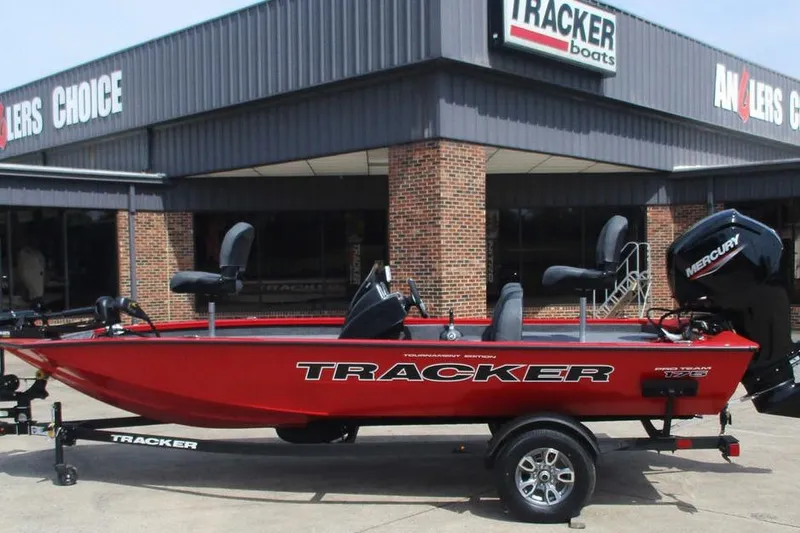 The Image of 2026 Tracker Pro Team 175 boat in red, displayed outside a Tracker dealership. - 1