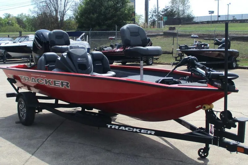 Slide: The Image of 2026 Tracker Pro Team 175 boat in vibrant red on a trailer, parked outdoors. - 11