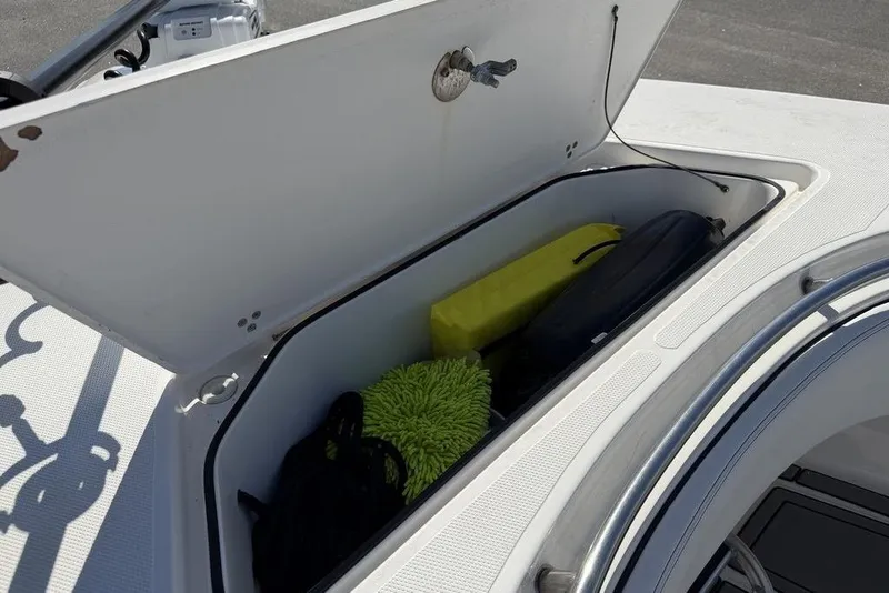 Slide: The Image of Open storage compartment on 2004 Fountain Bluewater 34 CC boat, containing various items. - 12