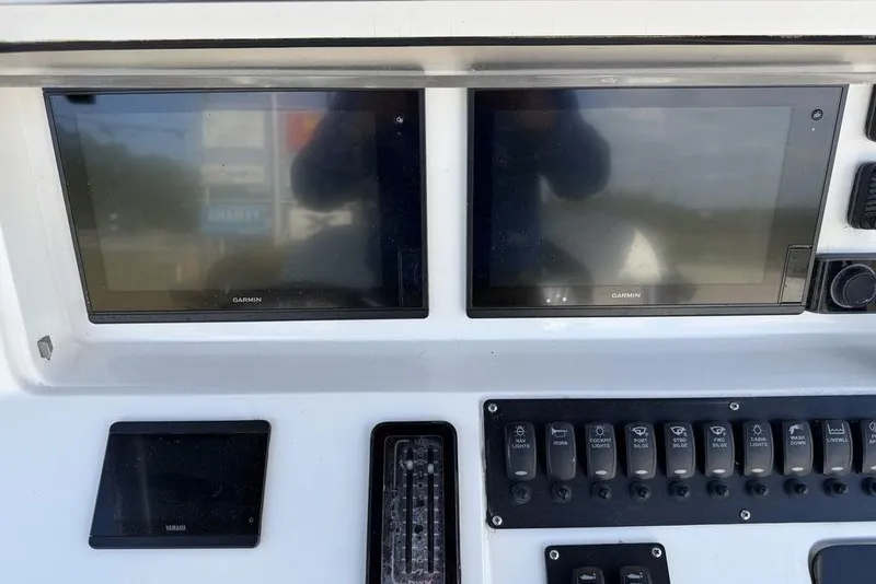 Slide: The Image of Control panel of 2004 Fountain Bluewater 34 CC with Garmin displays and switches. - 17