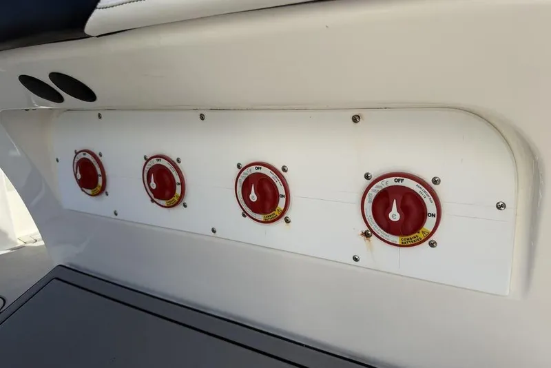 Slide: The Image of Control panel with four red switches on a 2004 Fountain Bluewater 34 CC boat. - 25