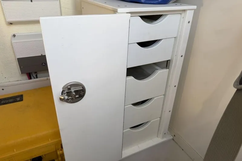 Slide: The Image of White storage cabinet with open door and drawers on a 2004 Fountain Bluewater 34 CC boat. - 31