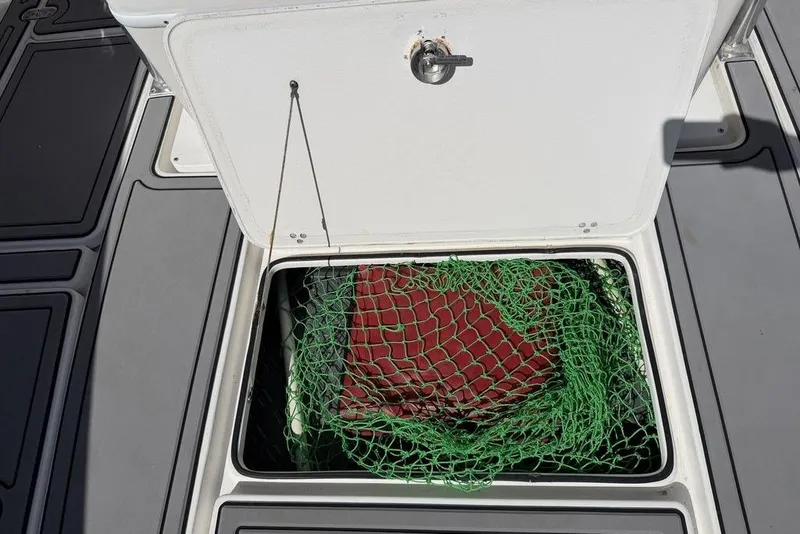 Slide: The Image of Open storage compartment on 2004 Fountain Bluewater 34 CC boat with green netting inside. - 35