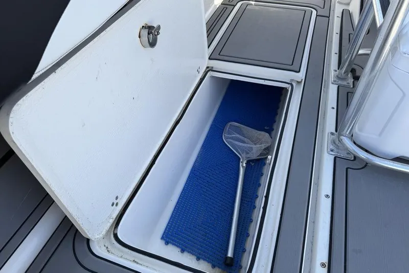 Slide: The Image of Open storage compartment on 2004 Fountain Bluewater 34 CC boat with fishing net inside. - 47