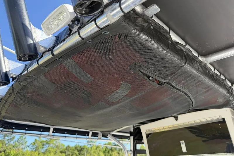 Slide: The Image of T-top storage on 2004 Fountain Bluewater 34 CC boat, featuring rod holders and netting. - 63