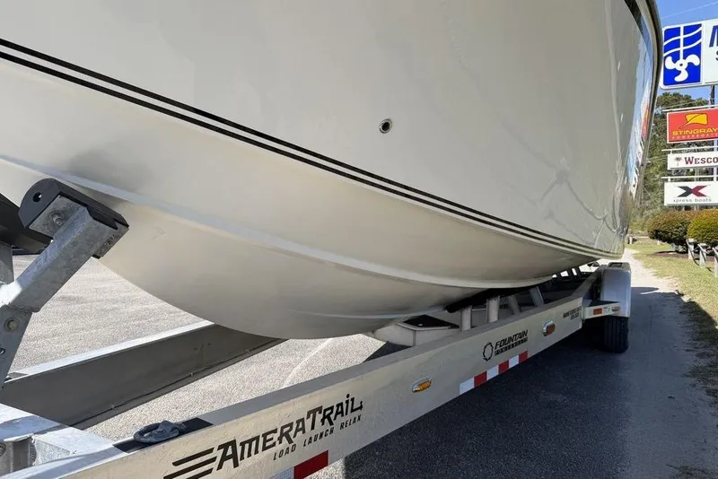 Slide: The Image of 2004 Fountain Bluewater 34 CC boat on AmeraTrail trailer, parked near dealership signs. - 65